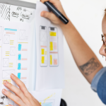 UX designer conducting an interview, showing a prototype to a user in a café to gather qualitative data.