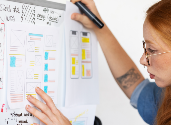 UX designer conducting an interview, showing a prototype to a user in a café to gather qualitative data.